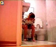 Hidden cam shooting babe peeing on the toilet